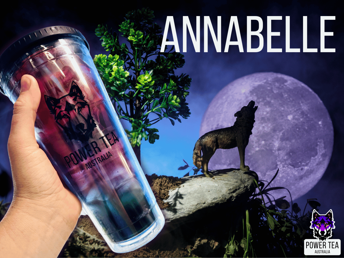a hand holding a large cup of Annabelle Loaded Energy Power Tea. The beverage is deep red blending into a deep green in a clear cup, with a wolf howling at the moon in the back ground.