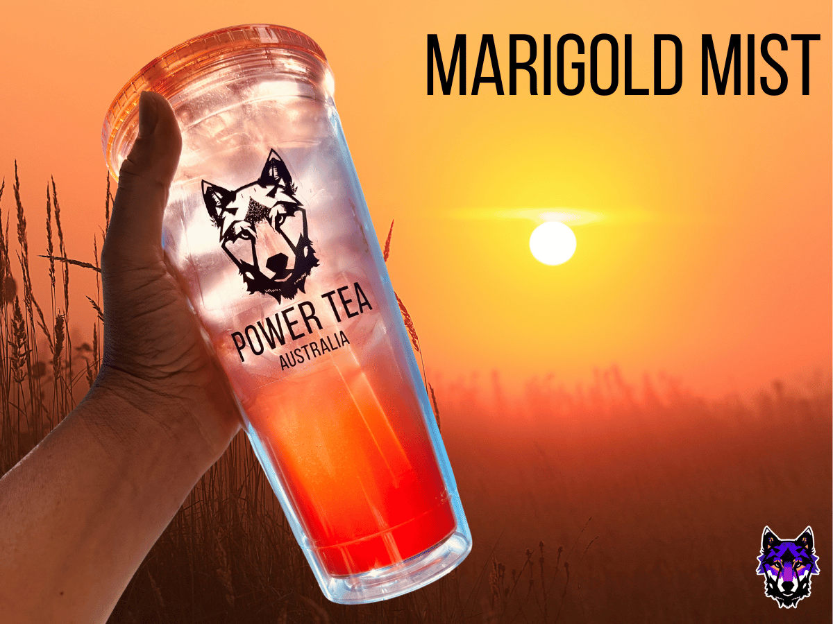 A cup filled with Marigold Mist Power Tea set against a sunsetting over a wheat field with a orange and hazy glow