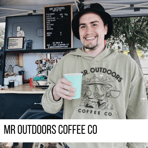Nic from Mr Outdoors Coffee standing with a cup in his hand next to his mobile coffee trailer